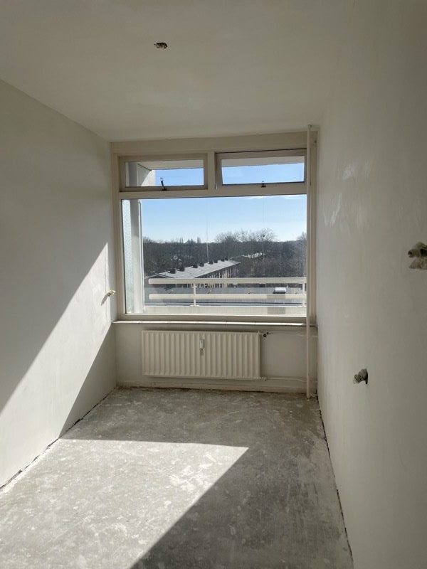 Renovatie in uitvoering: gladde stucwand naast onbewerkte muur